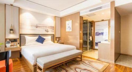 a bedroom with a large white bed and a bathroom at East Queen Hotel (Xi'an Beimen Metro Station) in Xi'an
