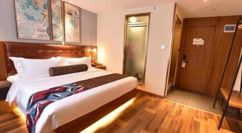 a hotel room with a large bed and a door at James Joyce Coffetel·Chengdu Chunxi in Chengdu