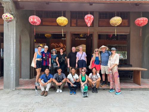 a group of people posing for a picture in front of a building at Vi Hostel-Motels-Hotel in Vũ Lâm