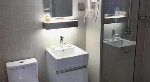 a bathroom with a white sink and a toilet at Jinjiang Inn Select Xuzhou High-speed Railway Station Kunpeng Road in Xuzhou