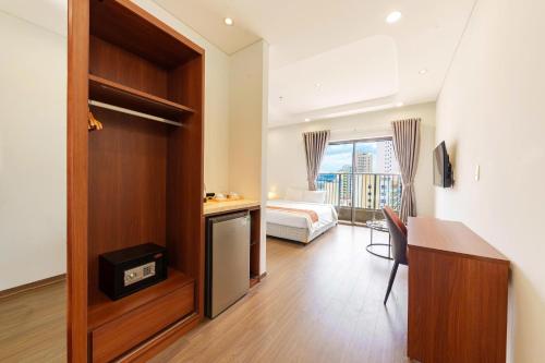 a hotel room with a bed and a desk and a room at D26 Nha Trang Hotel in Nha Trang