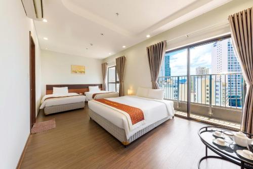 a hotel room with two beds and a large window at D26 Nha Trang Hotel in Nha Trang