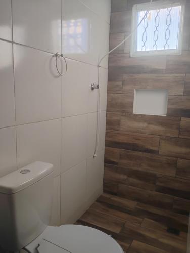 a bathroom with a toilet and a window at Quarto Casal próximo a Basílica in Aparecida