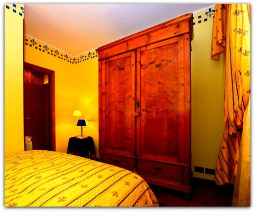 1 dormitorio con un gran armario de madera junto a una cama en Burlamacca, en Viareggio