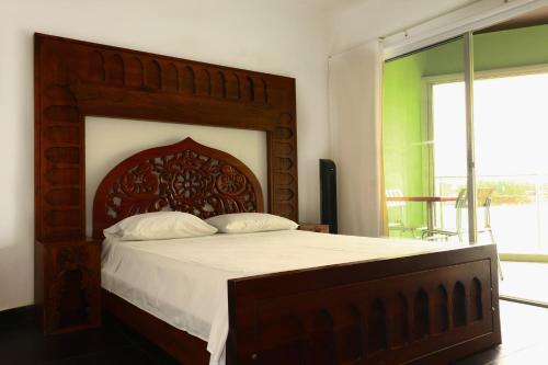 a bedroom with a large bed with a wooden headboard at Hotel Portobelo Guatape in Guatapé