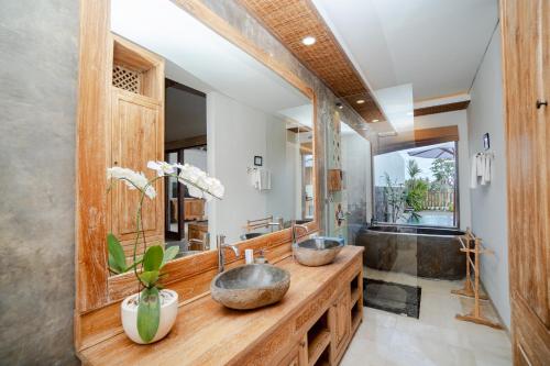 a bathroom with two sinks and a large mirror at Kudesa Bali in Ubud