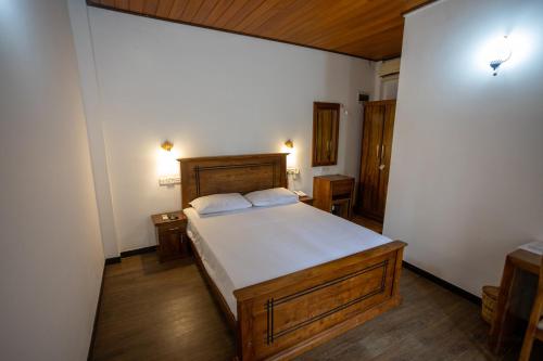 a bedroom with a large bed and wooden floors at Tree Trails Sigiriya in Sigiriya