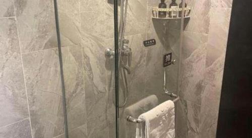 a shower with a glass door in a bathroom at Immersing Hotel Guilin Two Rivers and Four Lakes Dongxi Alley in Guilin