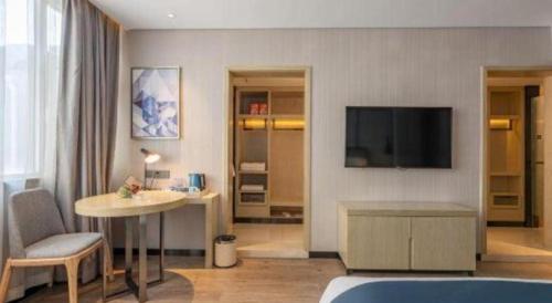 a hotel room with a living area with a television at Echarm Hotel Zibo Gaoqing Zhongcheng Inernational in Zibo