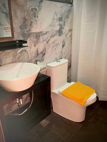 a bathroom with a white toilet and a sink at Kaia Siargao Villas in General Luna