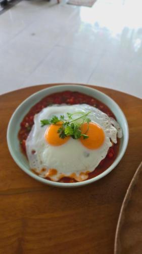 a plate of food with two fried eggs on a table at Vi Hostel-Motels-Hotel in Vũ Lâm