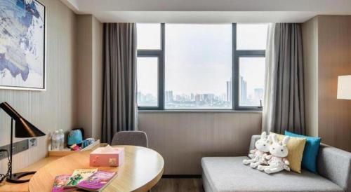 a living room with a table and a couch at Echarm Hotel Nanning Chaoyang Square River View in Nanning