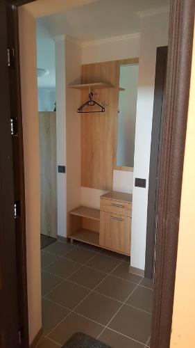 La salle de bains est pourvue d'une douche, d'un lavabo et d'un miroir. dans l'établissement L.E.C. Travel Apartments Ventspils, à Ventspils