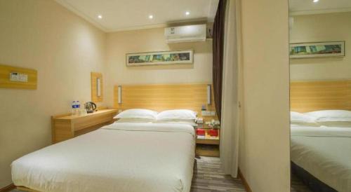 a hotel room with two beds and a bathroom at City Comfort Inn Wuhan Guanggu Textile University in Wuhan
