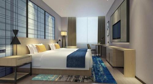 a hotel room with a large bed and a television at Echarm Hotel Anshun High-speed Railway Station Jichang Road in Anshun