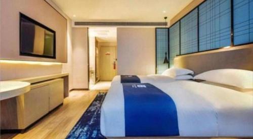 a large bedroom with a large bed and a bathroom at Echarm Hotel Anshun High-speed Railway Station Jichang Road in Anshun
