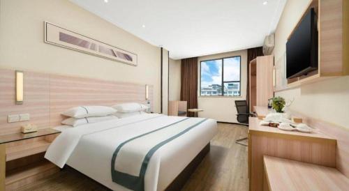 a hotel room with a large bed and a television at City Comfort Inn Nanning Dashatian Metro Station in Nanning