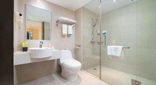 a bathroom with a toilet and a sink and a shower at City Comfort Inn Nanning Wuyi Fude in Nanning