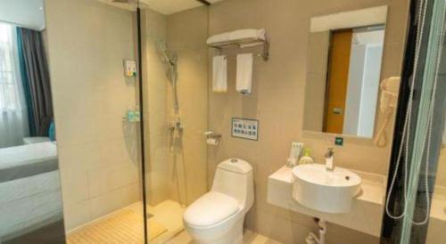a bathroom with a shower and a toilet and a sink at City Comfort Inn Yingcheng Railway Station Shanghe Square in Xiaogan
