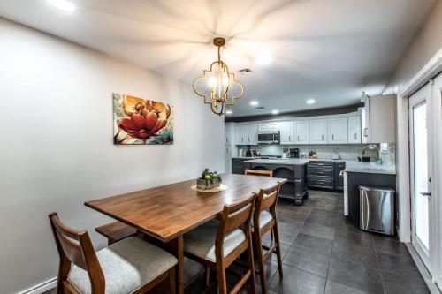 a kitchen and dining room with a wooden table and chairs at Classic Coastal Getaway Sleeps 34 - 2 Homes 2 Pools in Corpus Christi