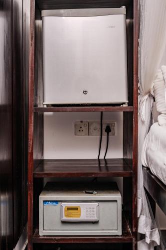 a shelf with a microwave and a box on it at Wasantha Garden Hotel Restaurant & Ayurvedic Treatment in Weligama