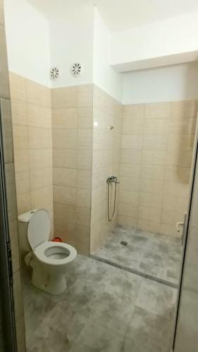 a bathroom with a shower with a toilet and a glass door at Sani Family Hotel in Byala