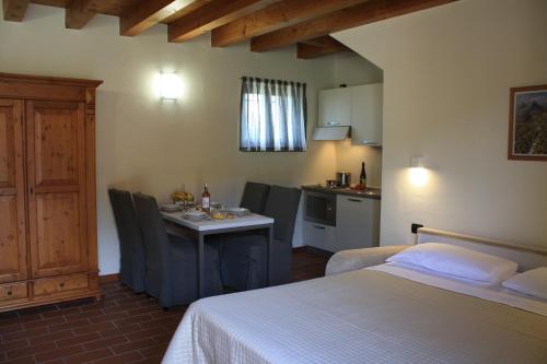 Un dormitorio con una cama y una mesa y una cocina. en Antica Corte la Valle, en Sona