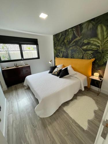 a bedroom with a large white bed and a bathroom at Heaven Ocin in Telde