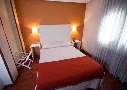 a small bed in a room with a window at Hotel Ovetense in Oviedo