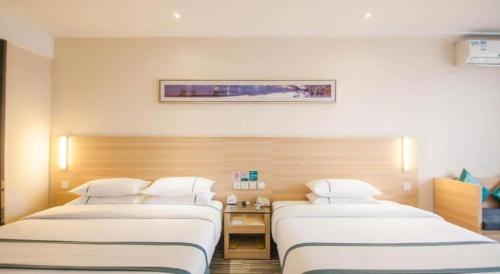 a hospital room with two beds in a room at City Comfort Inn Yichang Dongshan Three Gorges University Shuiyuecheng in Yichang
