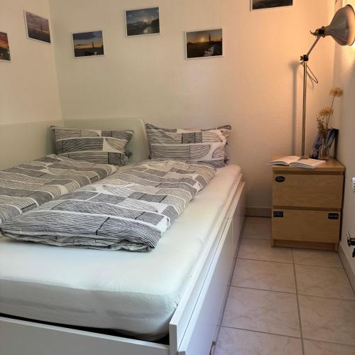 two beds in a bedroom with a lamp and a dresser at Elbinsel-Home ‘Alpakaliebe’ in Hamburg