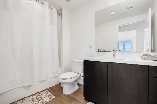 a bathroom with a toilet and a sink and a mirror at One Lux Stay - Hollywood in Los Angeles