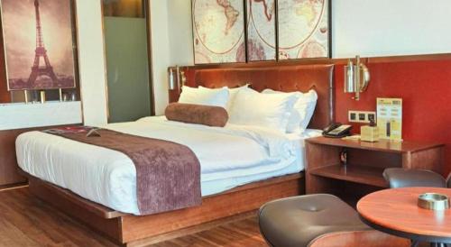 a bedroom with a bed and a desk and a table with a chair at James Joyce Coffetel Wuhan Gutian Er Road Metro Station in Wuhan