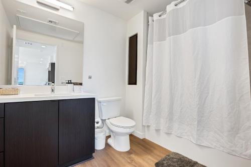a white bathroom with a toilet and a sink at One Lux Stay - Hollywood in Los Angeles