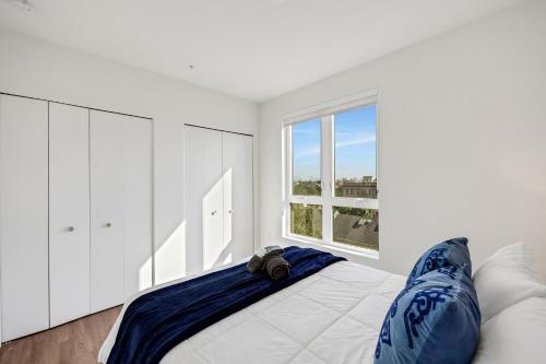 a bedroom with a bed with blue pillows and a window at One Lux Stay - Hollywood in Los Angeles