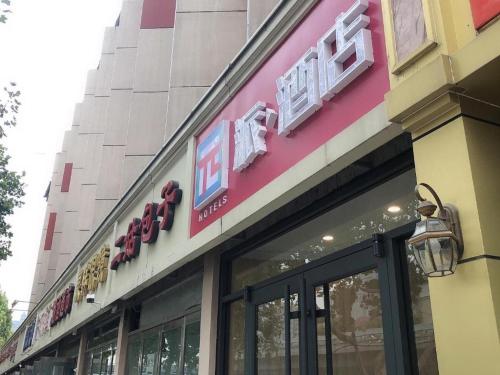 a store front of a building with a sign on it at PAI Hotels Shijiazhuang Railway Station West Square in Shijiazhuang