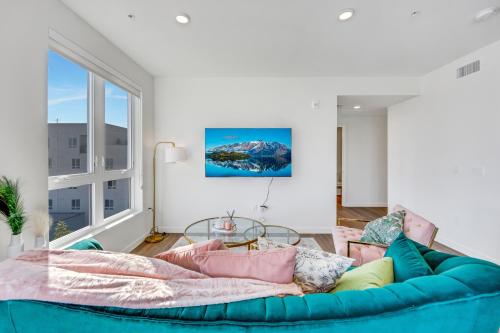 a living room with a blue couch and a large window at One Lux Stay - Hollywood in Los Angeles