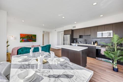 a living room with a table and a kitchen at One Lux Stay - Hollywood in Los Angeles