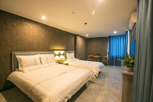 a hotel room with two beds in a room at City 118 Selected Hotel Tengzhou Railway Station in Tengzhou