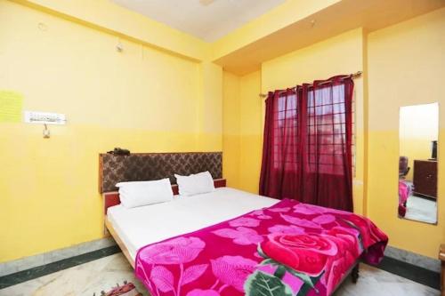 a bedroom with a bed with a pink blanket at HOTEL S-A-V-I-T-R-I PALACE Near Shree Baba Baidyanath Jyotirlinga - Free Wifi And Parking Facilities - Spacious and Fully Air Conditioned Rooms-Budget Hotel in Deoghar