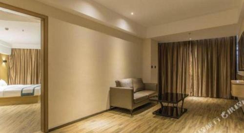 a hotel room with a chair and a bed and a mirror at City Comfort Inn Liuzhou Liucheng in Liuzhou