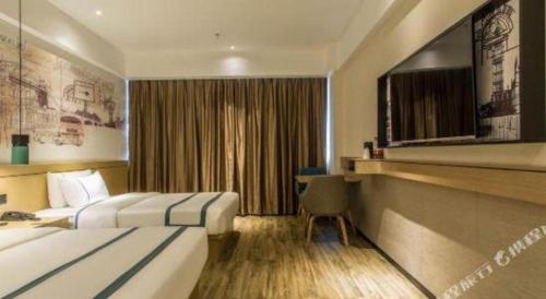 a hotel room with two beds and a television at City Comfort Inn Liuzhou Liucheng in Liuzhou