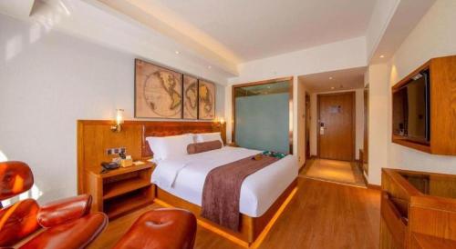 a hotel room with a bed and a television at James Joyce Coffetel Kunming Railway Station Huancheng Nan Road Metro Station in Kunming