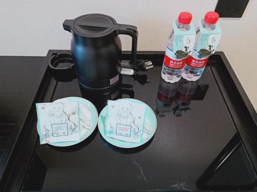 two bottles of water sitting on top of a stove at Xana Hotelle Wuxi Railway Station Zhongshan Road in Wuxi