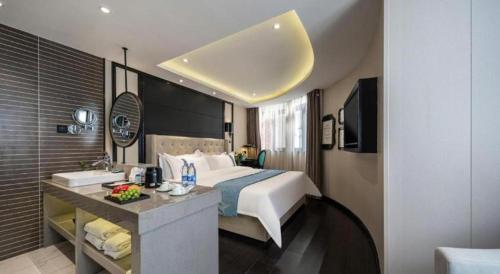a hotel room with a bed and a kitchen in it at Xana Hotelle Wuxi Railway Station Zhongshan Road in Wuxi