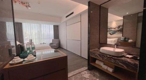 a bathroom with a sink and a large mirror at Xana Lite Huizhou Railway Station in Huizhou