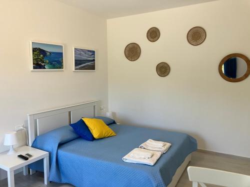 a small bedroom with a blue bed and a table at A due passi da Sansone in Portoferraio