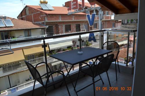 a balcony with a table and chairs on a balcony at Sissy's Boutique Apartments in Paralia Katerinis