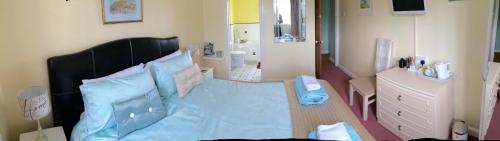 a bedroom with a bed with a blue sheet on it at Home from Home B&B in Hartland