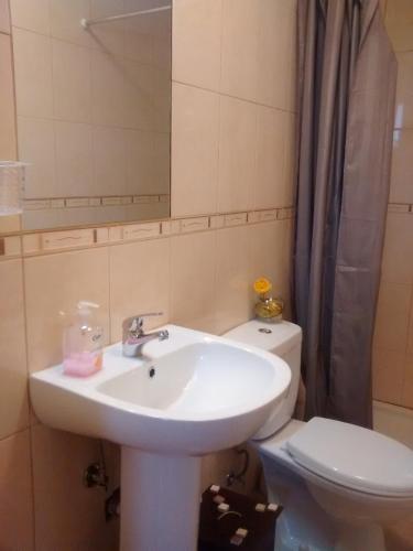 a bathroom with a sink and a toilet and a mirror at Casarao dos Reis in Caravela